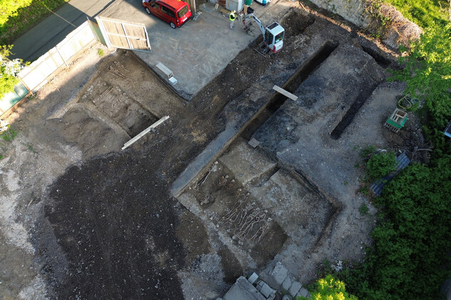 Detail poslední zkoumané linie společného hrobu č. 12 a 17 s kosterními ostatky padlých vojáků. Jsou uloženy v několika etážích střídavě hlavou k severu a k jihu. Severněji se podařilo zachytit individuální hroby východo-západní orientace (foto Egon Ditmar, 9. 5. 2025).